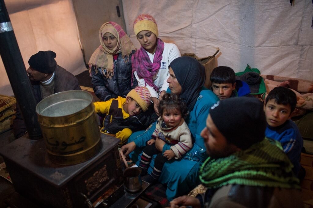 This refugee family from Homs, Syria, kept warm by their stove in Terbol, a tented settlement in Lebanon’s Bekaa Valley.